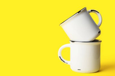 Sarı arkaplanda seramik bardaklar