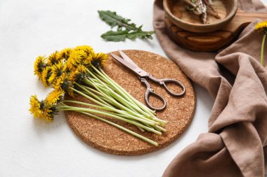 Beyaz arka planda karahindiba, makas ve peçeteyle durun.