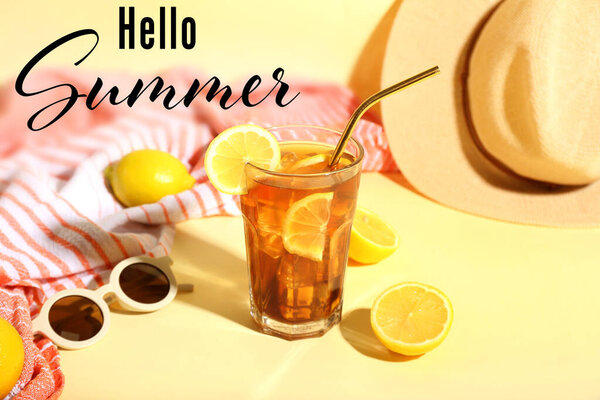 Glass of tasty Long Island iced tea, sunglasses, hat and towel on color background. Hello, summer
