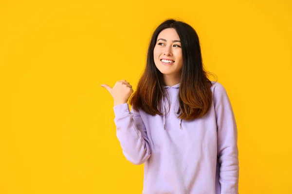 Inviting Young Asian Woman Pointing Something Yellow Background — Stock Photo, Image