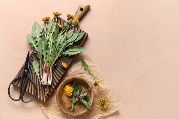 Tahta, kase, makas ve bej arkaplan üzerine parşömen kağıdı olan sarı karahindibalar.