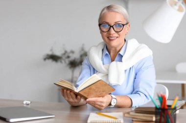 Bayan öğretmen evde ders veriyor.