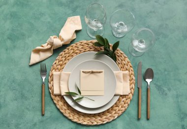 Table setting with blank card on green background