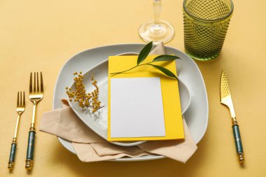 Boş kart ve renk arkaplanında çiçek dekoru olan şık masa ayarları