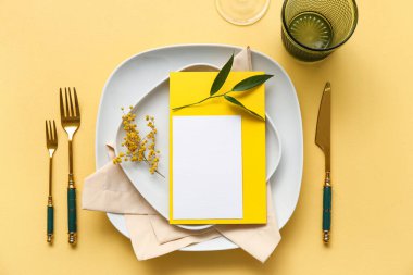 Boş kart ve renk arkaplanında çiçek dekoru olan şık masa ayarları