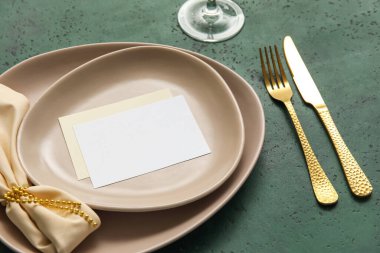 Yeşil arkaplanda boş kartı olan şık masa ayarları