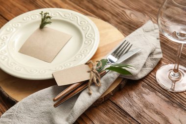 Ahşap masa üzerinde boş kartı olan şık masa ayarları, yakın plan.