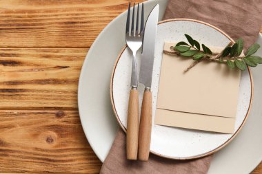 Çiçek desenli masa ayarları ve tahta arka planda boş kart, yakın plan