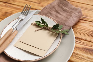 Çiçek desenli masa ayarları ve tahta arka planda boş kart, yakın plan