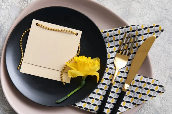 Gri arka planda boş kart ve narsisli masa ayarı, yakın plan