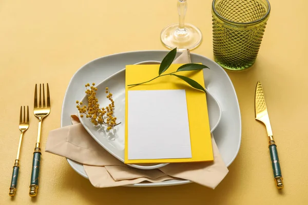 Boş kart ve renk arkaplanında çiçek dekoru olan şık masa ayarları