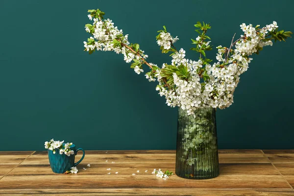 Vase Und Tasse Mit Blühenden Ästen Auf Holztisch Neben Grüner — Stockfoto