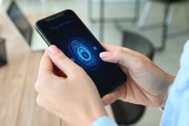 Akıllı telefonu kilitli ekranlı bir kadın tutuyor.