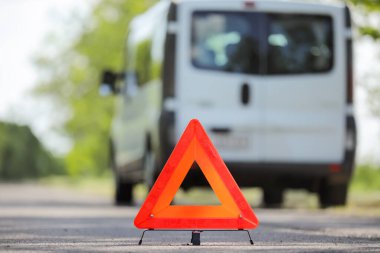 Acil dur işareti ve arka planda bulanık araba