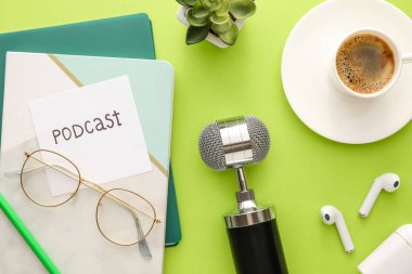 Mikrofon, kulaklık, gözlük ve kağıt üzerinde PODCAST kelimesi, yakın plan
