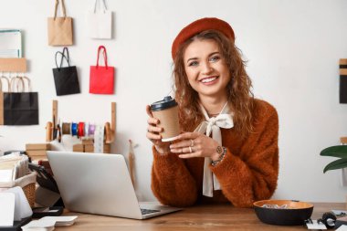 Female business owner drinking coffee in shop