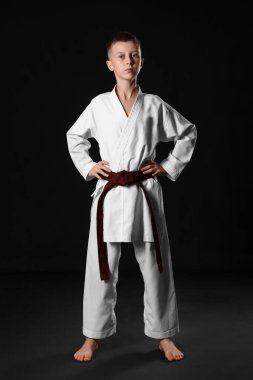 Siyah arka planda karategi yapan çocuk.