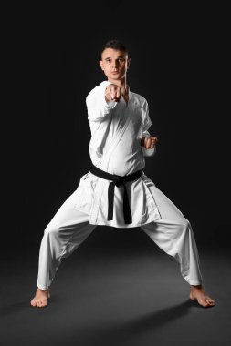 Man practicing karate on dark background