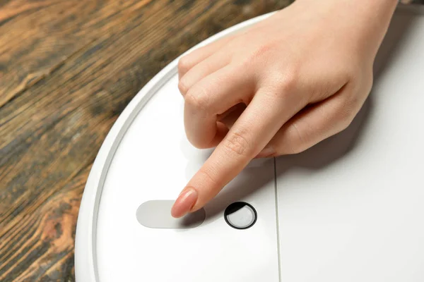Woman Turning Robot Vacuum Cleaner Wooden Background Closeup — 스톡 사진