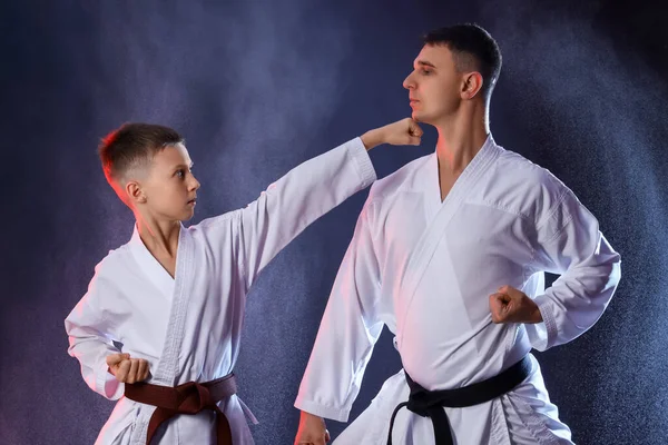 Niño Practicando Karate Con Instructor Sobre Fondo Oscuro —  Fotos de Stock