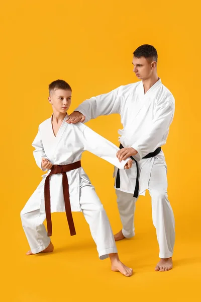 Niño Practicando Karate Con Instructor Sobre Fondo Amarillo —  Fotos de Stock