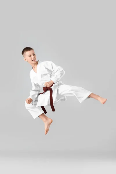 Niño Practicando Karate Sobre Fondo Claro —  Fotos de Stock