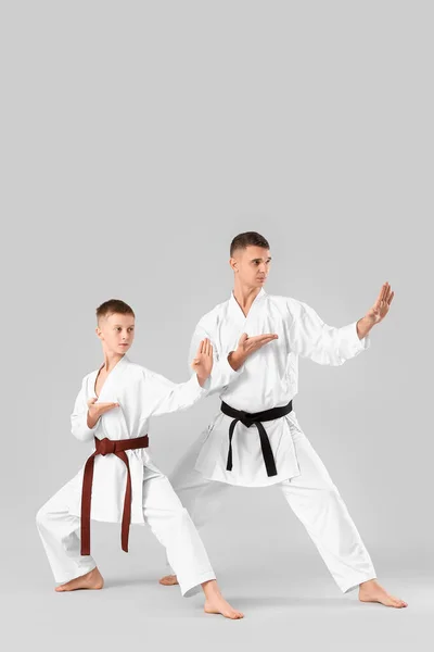 Chłopiec Ćwiczy Karate Instruktorem Lekkim Tle — Zdjęcie stockowe