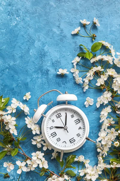 Blooming Spring Branches Alarm Clock Blue Background Top View — Zdjęcie stockowe