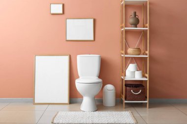 Tuvalet klozeti ve askısı olan temiz, modern bir tuvalet.