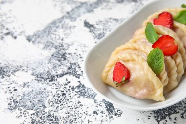 Arka planda lezzetli çilekli börek kasesi, yakın plan.