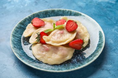 Mavi arka planda lezzetli çilekli börek tabağı, yakın plan.