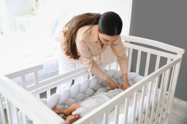 Genç anne ve tapılası bebeği evde uyuyor.