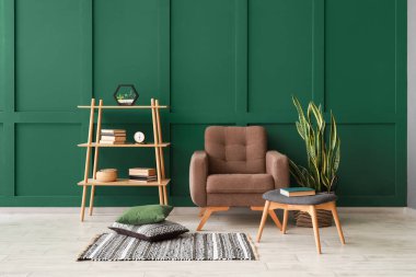 Renkli duvarın yanında koltuk ve raf ünitesi olan şık bir oda.