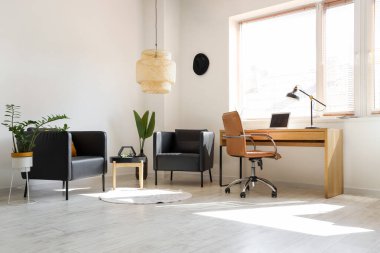 Çalışma yeri ve siyah koltukları olan modern ofis.