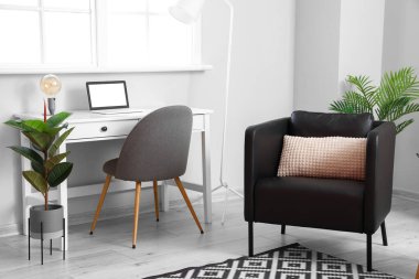 Siyah koltuğu ve işyeri olan modern oturma odasının içinde.