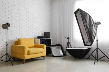 Rahat koltuk ve beyaz tuğla duvarın yanında farklı ekipmanlar.