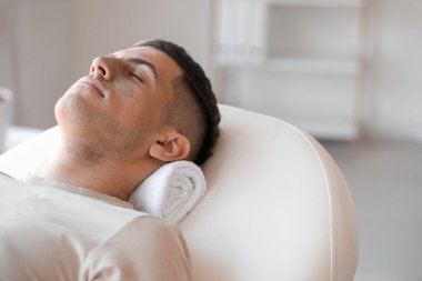 Kuaförde uygulamalı kil maskeli yakışıklı bir adam, yakın plan.