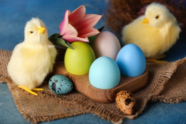 Tatlı tavuklar, Paskalya yumurtaları ve çiçekler masada.