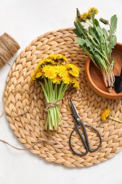 Karahindiba, kase, halat, makas ve beyaz arka planda kürekle hasır.