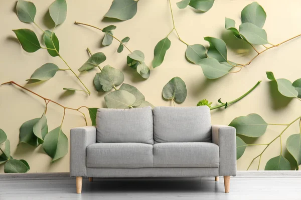 Stylish Grey Sofa Color Wall Printed Green Leaves — стоковое фото