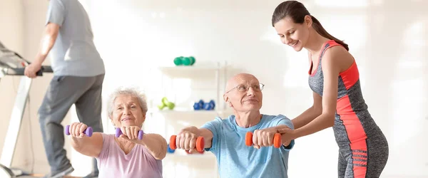 Young Trainer Helping Elderly People Exercises Gym — Stok fotoğraf