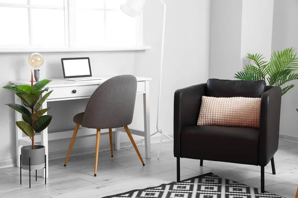 Siyah koltuğu ve işyeri olan modern oturma odasının içinde.