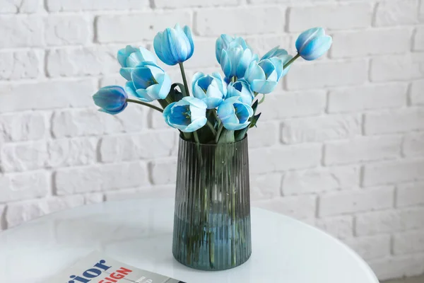 Wazon Niebieskimi Tulipanami Magazynem Stole Pobliżu Ściany Białej Cegły — Zdjęcie stockowe
