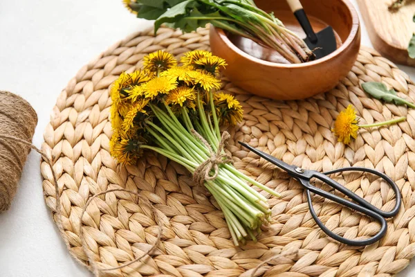 Beyaz arka planda karahindiba, kase, kürek ve makaslı hasır, yakın plan