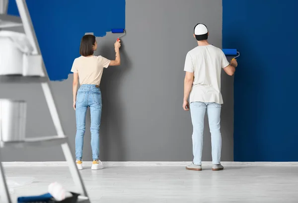 Young Couple Painting Wall Room Back View — стоковое фото