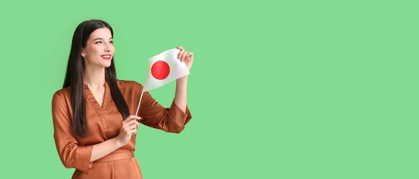 緑の背景に日本の国旗を持つ美しい若い女性のためのテキストのためのスペース — ストック写真