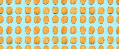 Many tasty potato chips on light blue background. Texture for design