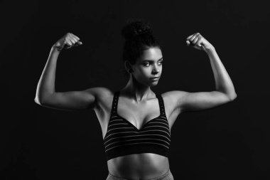 Siyah beyaz, siyah arka planda Afro-Amerikan genç bir kadının portresi.