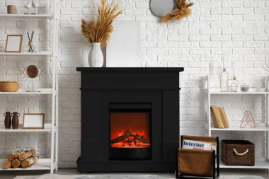 Interior of modern living room with black fireplace and shelf units near white brick wall