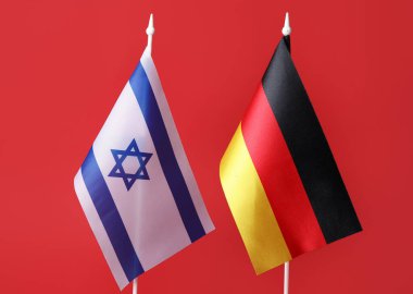 Kızıl zemin üzerinde İsrail ve Almanya bayrakları, yakın plan
